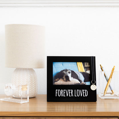 Decorative photo album with a dog picture and 'Forever Loved' text on a table.