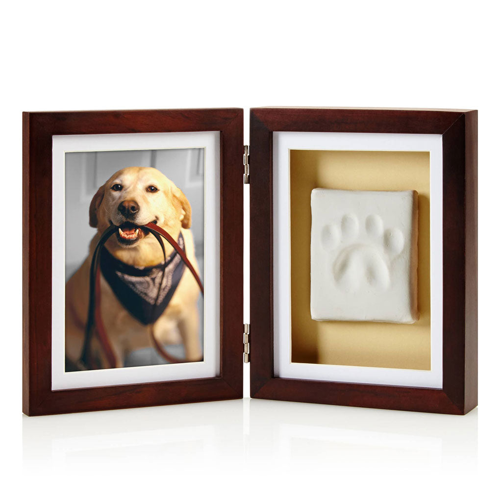 Wooden photo frame with a picture of a dog and a paw print inside on a white background